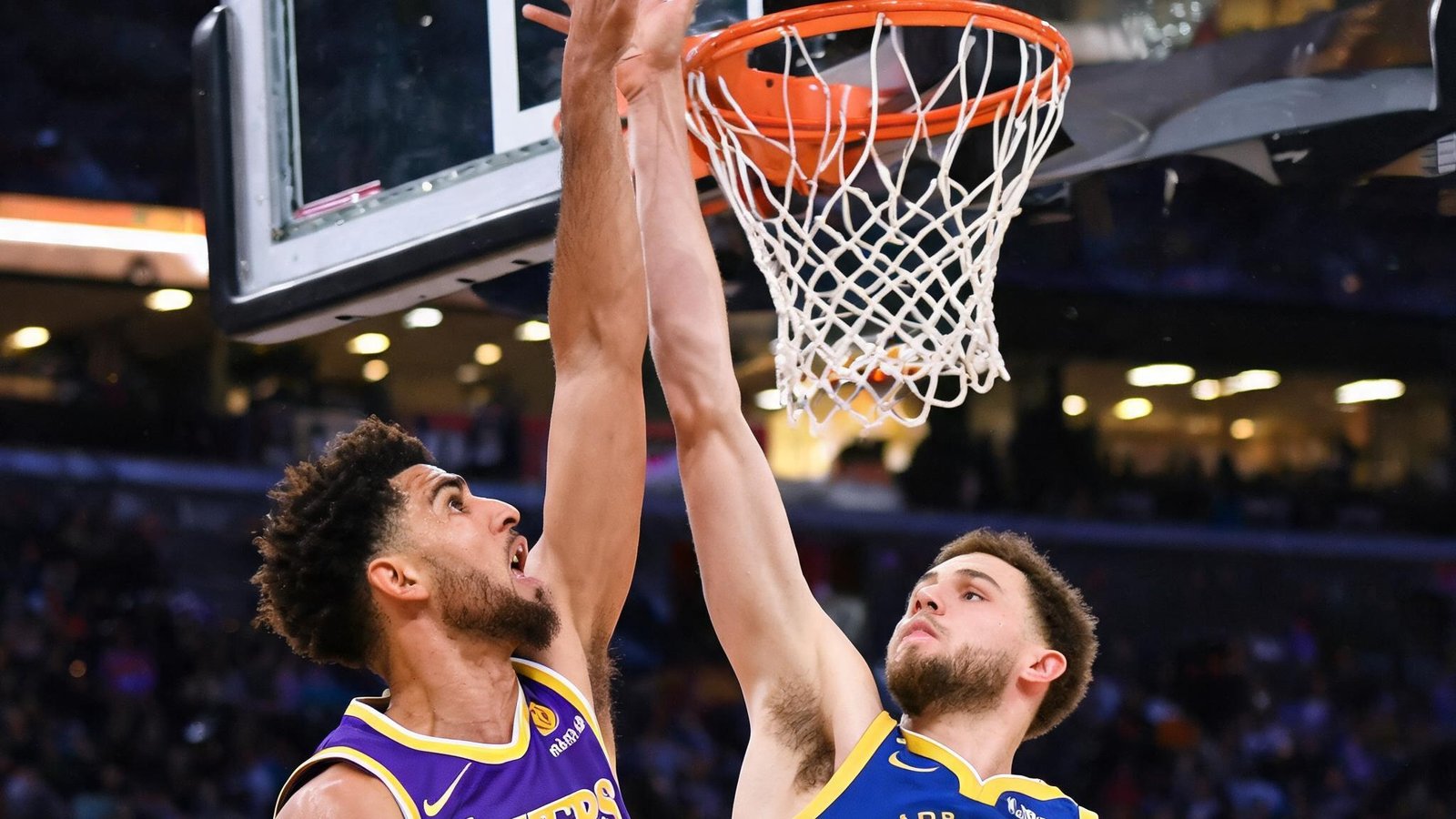 NBA比赛湖人队与勇士队球员在篮下争抢篮板球的激烈瞬间，特写镜头